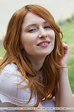 Dariya a in white dress, spreading her legs wide open wjile seated on a park bench