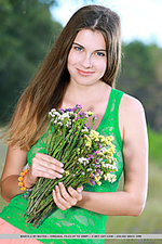 Beautiful busty marta e dressed in pink and green holding a lovely bouquet of flowers