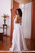 Divina a sensually removes her white long dress, revealing her smooth, athletic body garbed in string lingerie and sheer stockings that amplified her erotic looks.