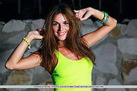 Fernanda looks fresh and vibrant at dusk, her stunning beauty and athletic physique complimented by her bright green tank top and cut-off denim shorts.